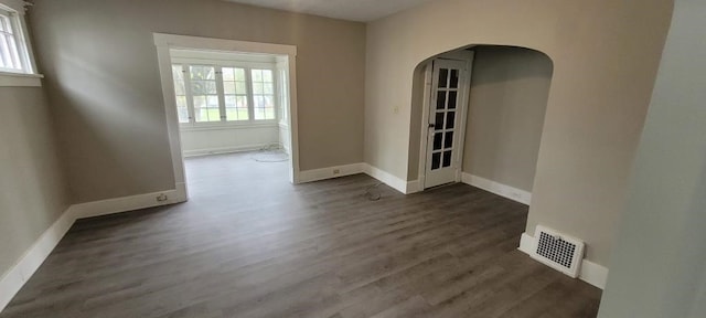 304 Elm Ave, Sharon, PA 16146 - empty room featuring healthy amount of natural light, arched walkways, and dark wood-type flooring