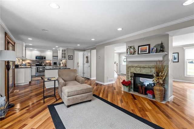 859 Boulder Dr, Bethel Park, PA 15102 - living room with recessed lighting, light wood finished floors, crown molding, and a tiled fireplace