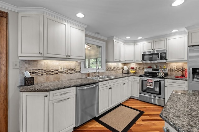 859 Boulder Dr, Bethel Park, PA 15102 - kitchen with appliances with stainless steel finishes, white cabinetry, light wood-style floors, ornamental molding, and tasteful backsplash