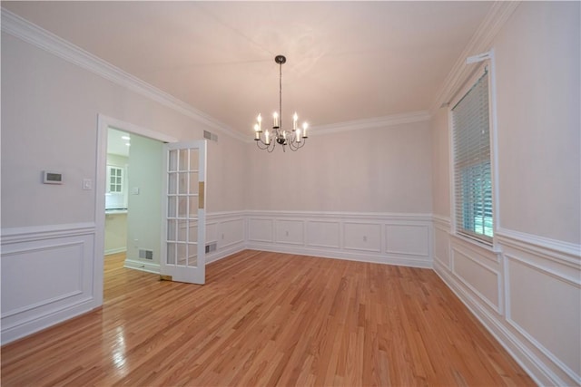 503 Sharon Rd, Moon/Crescent Twp, PA 15108 - unfurnished room with a chandelier, light wood finished floors, crown molding, a decorative wall, and wainscoting
