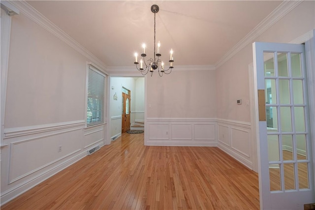 503 Sharon Rd, Moon/Crescent Twp, PA 15108 - unfurnished dining area with a chandelier, light wood-style floors, ornamental molding, wainscoting, and a decorative wall
