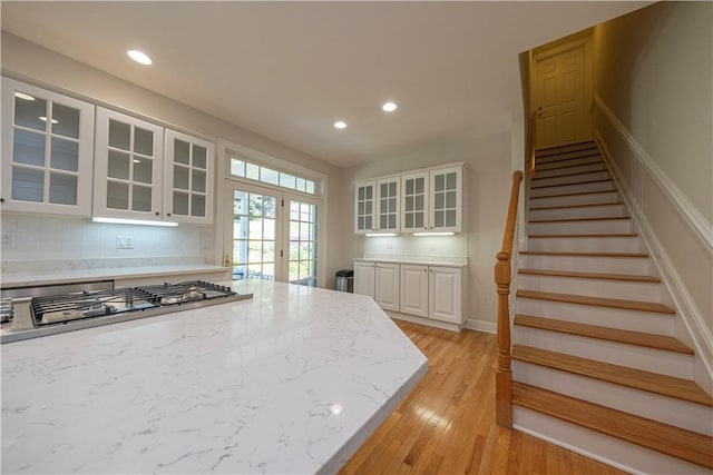 503 Sharon Rd, Moon/Crescent Twp, PA 15108 - kitchen with stainless steel gas cooktop, white cabinets, recessed lighting, glass insert cabinets, and light wood finished floors