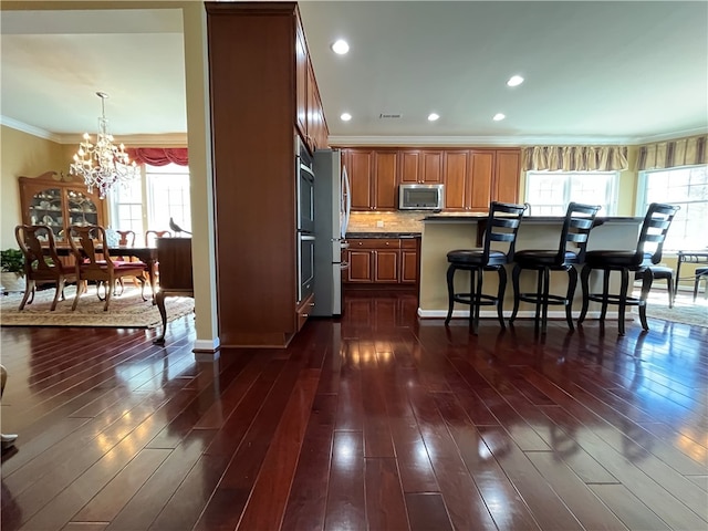 261 Patriot Ln, Economy, PA 15042 - kitchen featuring appliances with stainless steel finishes, a chandelier, a kitchen bar, healthy amount of natural light, and ornamental molding