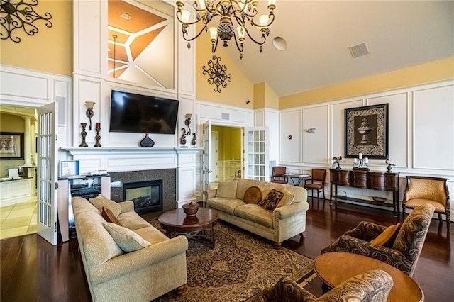 261 Patriot Ln, Economy, PA 15042 - living room featuring a decorative wall, high vaulted ceiling, a chandelier, wood finished floors, and a large fireplace