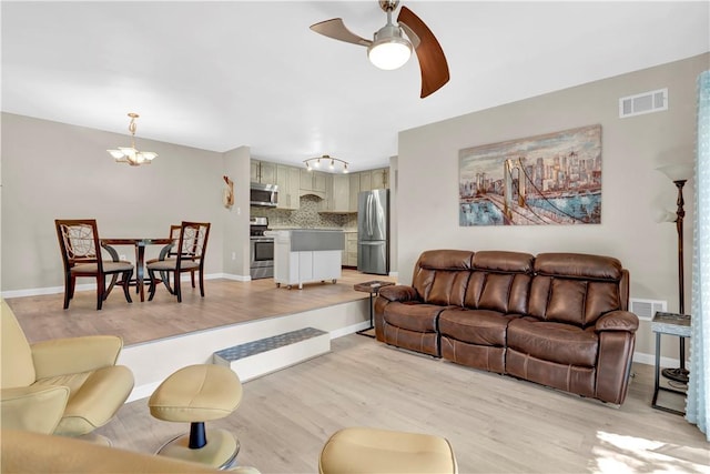 1410 Kenzie Dr, Robinson Twp, PA 15205 - living room with light wood-style floors, a ceiling fan, and a chandelier