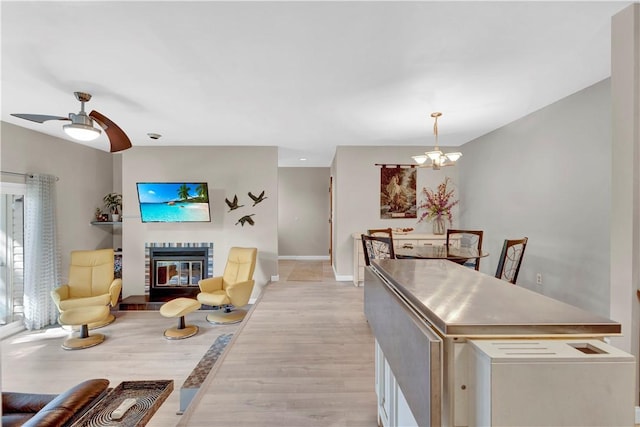 1410 Kenzie Dr, Robinson Twp, PA 15205 - living area with light wood-style flooring, a glass covered fireplace, a chandelier, and ceiling fan