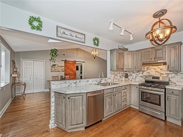 670 Sugar Camp Rd, Finleyville, PA 15332 - kitchen featuring stainless steel appliances, a chandelier, a barn door, vaulted ceiling, and decorative backsplash