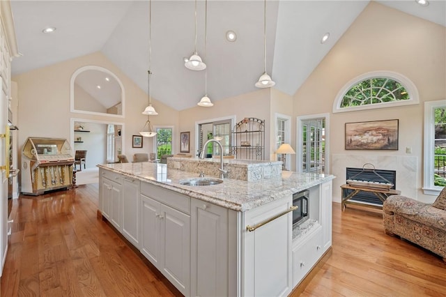 532 Salem Heights Dr, Pine Twp Nal, PA 15044 - kitchen featuring high vaulted ceiling, white cabinetry, an island with sink, light wood finished floors, and stainless steel microwave