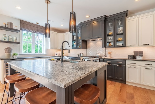 421 Johnston Rd, Saint Clair, PA 15241 - kitchen featuring beverage cooler, a breakfast bar area, recessed lighting, light stone counters, and light wood-style flooring