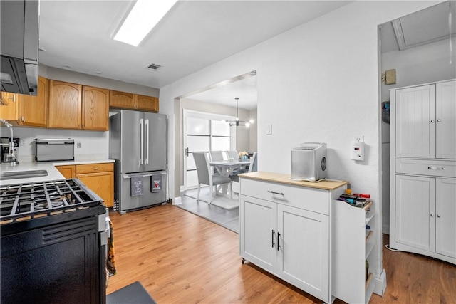 1434 Washington Blvd, Port Vue, PA 15133 - kitchen featuring freestanding refrigerator, light wood-style floors, light countertops, and gas stove