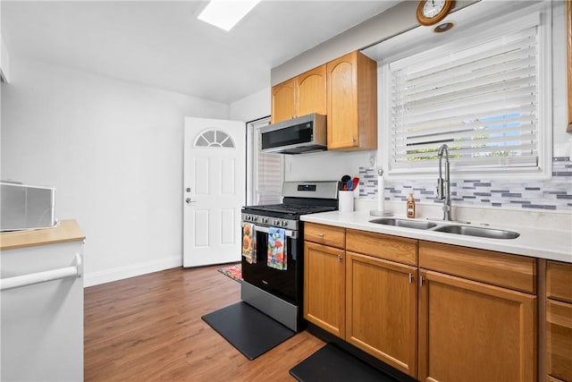 1434 Washington Blvd, Port Vue, PA 15133 - kitchen with appliances with stainless steel finishes, decorative backsplash, light wood-type flooring, and light countertops