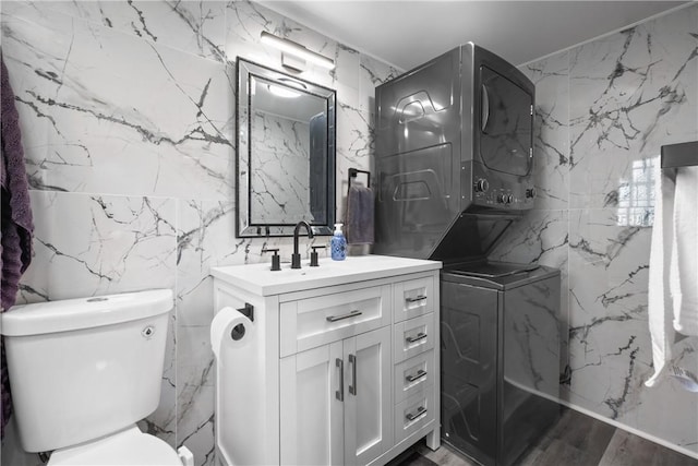 1434 Washington Blvd, Port Vue, PA 15133 - bathroom with stacked washer and clothes dryer, tile walls, vanity, and stone wall