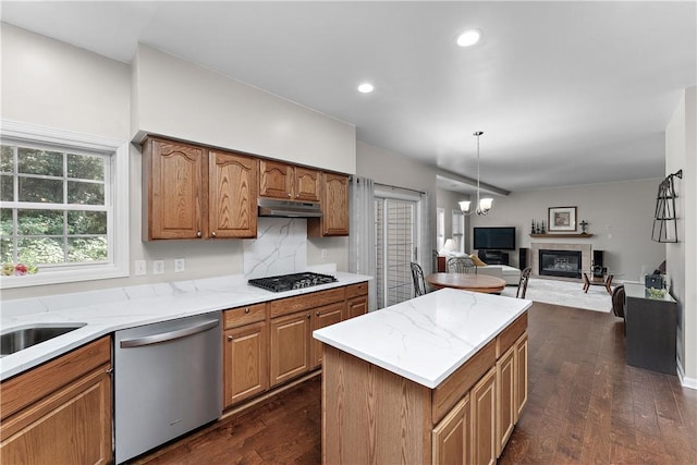 3013 Chessman St, Hampton, PA 15101 - kitchen with appliances with stainless steel finishes, under cabinet range hood, a glass covered fireplace, dark wood finished floors, and open floor plan