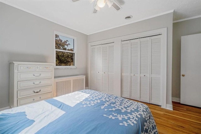 6403 Beacon St, Squirrel Hill, PA 15217 - bedroom with radiator heating unit, two closets, wood finished floors, crown molding, and ceiling fan