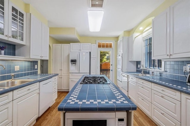 6403 Beacon St, Squirrel Hill, PA 15217 - kitchen featuring white appliances, white cabinets, tile countertops, and tasteful backsplash