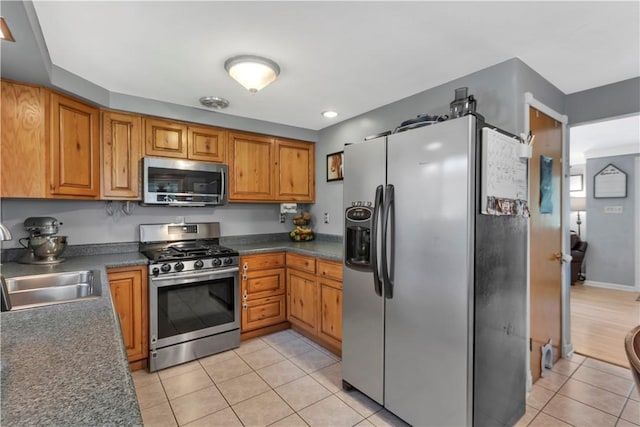 391 Wendel Rd, Pa, PA 15642 - kitchen with stainless steel appliances, light tile patterned floors, dark countertops, and brown cabinets