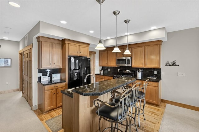 116 Lakeside Trl, Seven Springs Resort, PA 15622 - kitchen with stainless steel microwave, black fridge, stove, tile countertops, and a breakfast bar
