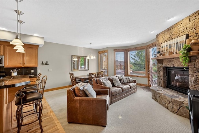 116 Lakeside Trl, Seven Springs Resort, PA 15622 - living room with light carpet, a stone fireplace, and a chandelier