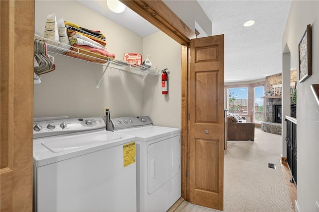 116 Lakeside Trl, Seven Springs Resort, PA 15622 - washroom featuring washer and dryer, light colored carpet, a fireplace, and a textured ceiling