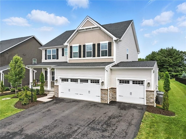 3049 Eagle Ridge Dr, Middlesex Twp, PA 16059 - view of front of house featuring asphalt driveway, board and batten siding, stone siding, an attached garage, and a front lawn