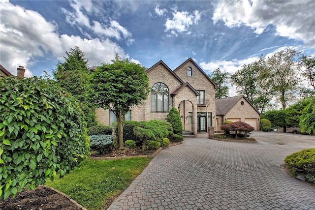 410 Lorenzo Ln, Hempfield Twp, PA 15642 - french provincial home with brick siding, decorative driveway, and a garage