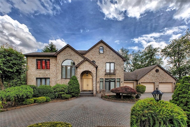 410 Lorenzo Ln, Hempfield Twp, PA 15642 - french provincial home featuring decorative driveway, brick siding, and a garage