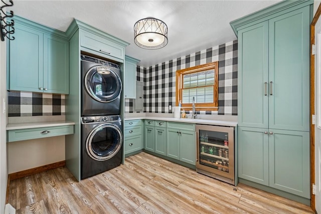 409 Park Rd, Bullskin Twp, PA 15683 - washroom with wine cooler, stacked washing machine and dryer, wallpapered walls, light wood-type flooring, and cabinet space