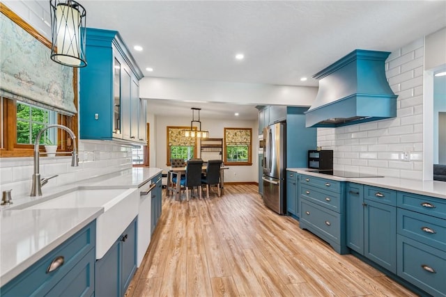 409 Park Rd, Bullskin Twp, PA 15683 - kitchen with stainless steel fridge with ice dispenser, premium range hood, white dishwasher, blue cabinets, and light wood-style floors
