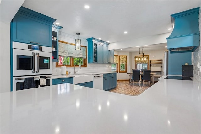 409 Park Rd, Bullskin Twp, PA 15683 - kitchen featuring white appliances, blue cabinets, tasteful backsplash, custom range hood, and glass insert cabinets