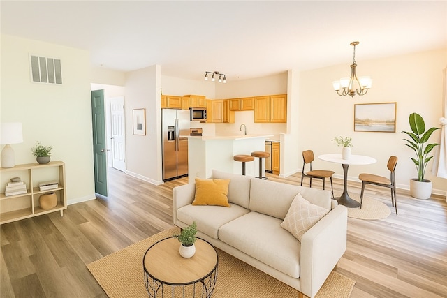 114 Southern Valley Ct, Adams Twp, PA 16046 - living room with a chandelier and light wood-style floors
