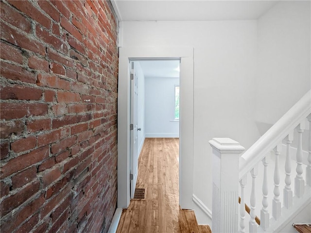 7304 Forest Way, Homewood-Brushton, PA 15208 - corridor featuring brick wall, wood finished floors, and an upstairs landing
