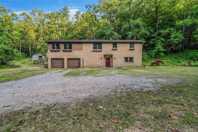 5028 W Smithfield St, Elizabeth Twp/Boro, PA 15135 - view of front of property with a garage, brick siding, and a wooded view