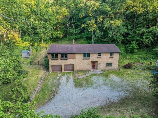 5028 W Smithfield St, Elizabeth Twp/Boro, PA 15135 - view of front of property featuring driveway, a garage, a wooded view, and brick siding