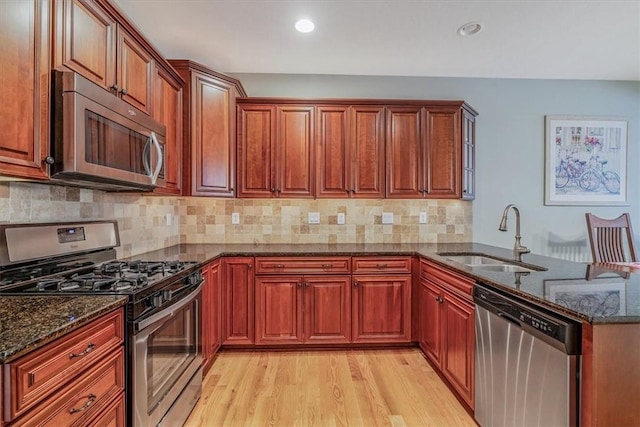 1303 Shinnecock Ct, Adams Twp, PA 16046 - kitchen with stainless steel appliances, a peninsula, dark stone counters, light wood-style floors, and tasteful backsplash