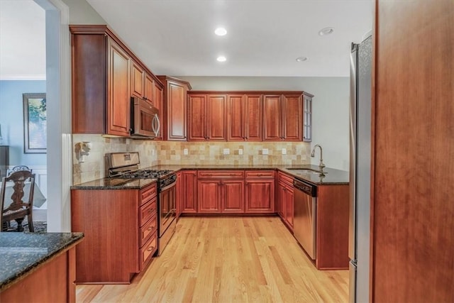 1303 Shinnecock Ct, Adams Twp, PA 16046 - kitchen with stainless steel appliances, light wood-style flooring, dark stone counters, backsplash, and recessed lighting