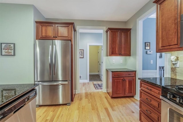 1303 Shinnecock Ct, Adams Twp, PA 16046 - kitchen featuring appliances with stainless steel finishes, dark stone countertops, light wood-style floors, and brown cabinets