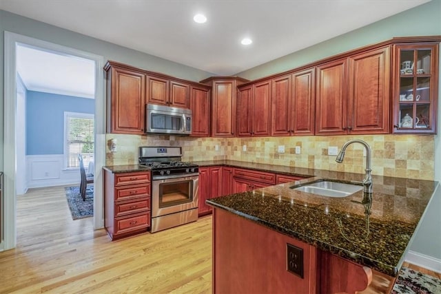 1303 Shinnecock Ct, Adams Twp, PA 16046 - kitchen featuring appliances with stainless steel finishes, dark stone counters, a peninsula, light wood-style flooring, and glass insert cabinets
