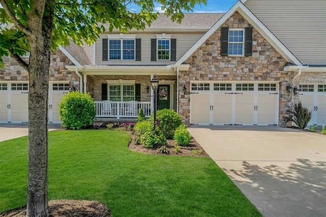 1303 Shinnecock Ct, Adams Twp, PA 16046 - craftsman house with driveway, covered porch, a front yard, and stone siding