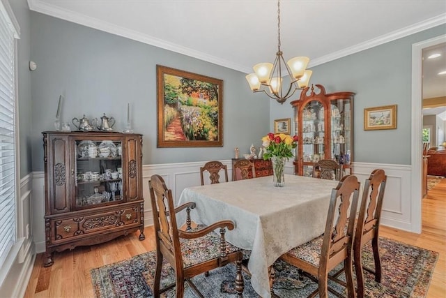 1303 Shinnecock Ct, Adams Twp, PA 16046 - dining space with ornamental molding, light wood-style floors, a chandelier, a decorative wall, and a wainscoted wall