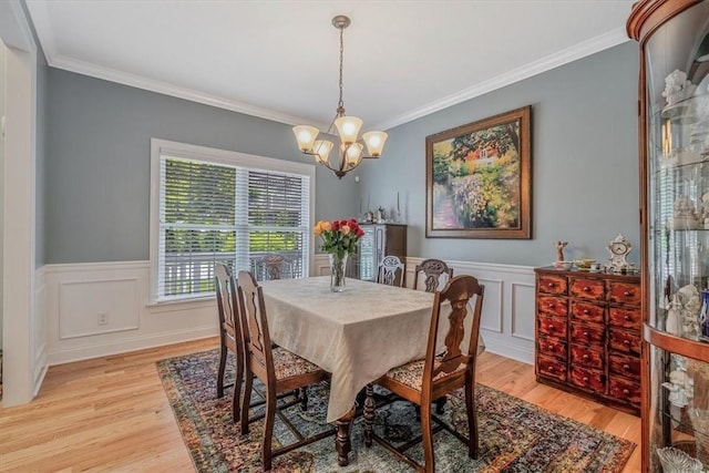1303 Shinnecock Ct, Adams Twp, PA 16046 - dining space featuring light wood-style floors, crown molding, a chandelier, a wainscoted wall, and a decorative wall