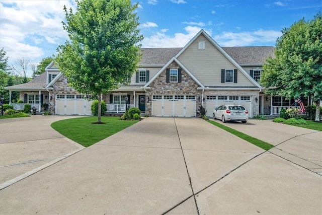 1303 Shinnecock Ct, Adams Twp, PA 16046 - craftsman house with stone siding, covered porch, concrete driveway, a front lawn, and an attached garage
