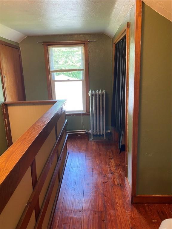 118 Delaware Ave, Scottdale, PA 15683 - corridor with radiator heating unit, lofted ceiling, dark wood finished floors, and a textured ceiling