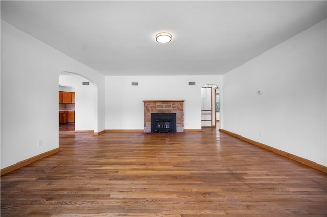 389 Mercer Rd, Hempfield Twp Mer, PA 16125 - unfurnished living room featuring wood finished floors, a stone fireplace, and arched walkways