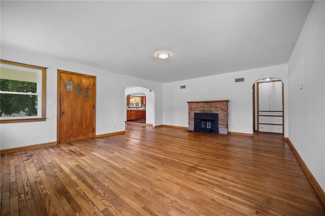 389 Mercer Rd, Hempfield Twp Mer, PA 16125 - unfurnished living room with arched walkways, hardwood / wood-style floors, and a stone fireplace