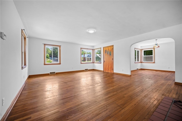 389 Mercer Rd, Hempfield Twp Mer, PA 16125 - unfurnished living room featuring arched walkways, healthy amount of natural light, and hardwood / wood-style flooring