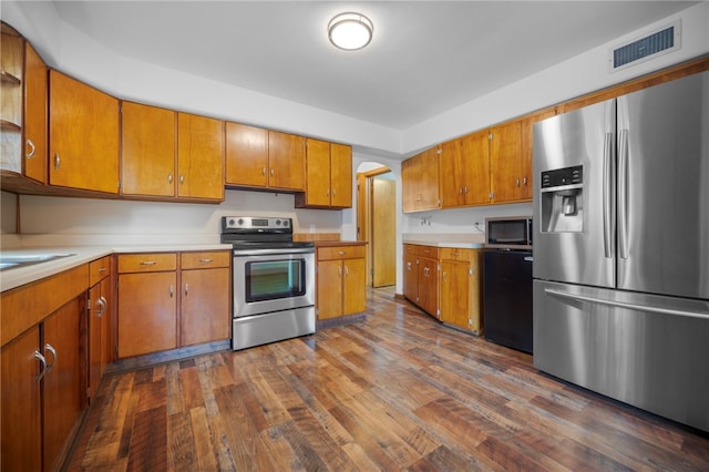 389 Mercer Rd, Hempfield Twp Mer, PA 16125 - kitchen featuring appliances with stainless steel finishes, brown cabinetry, dark wood-style floors, and light countertops