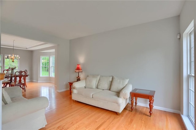 216 Beagle Dr, Moon/Crescent Twp, PA 15108 - living area with a chandelier, light wood-type flooring, and a tray ceiling
