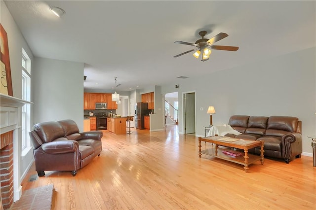 216 Beagle Dr, Moon/Crescent Twp, PA 15108 - living room with light wood-type flooring, a brick fireplace, and ceiling fan
