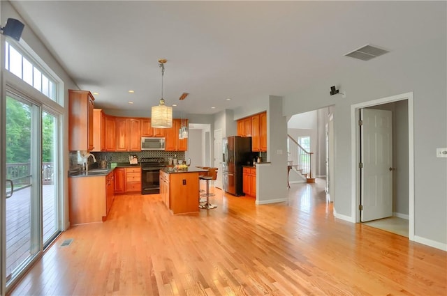 216 Beagle Dr, Moon/Crescent Twp, PA 15108 - kitchen featuring electric range, stainless steel microwave, refrigerator with ice dispenser, light wood-type flooring, and dark countertops