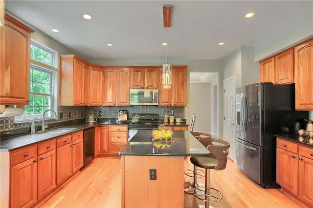 216 Beagle Dr, Moon/Crescent Twp, PA 15108 - kitchen featuring black appliances, light wood finished floors, a kitchen breakfast bar, dark countertops, and recessed lighting